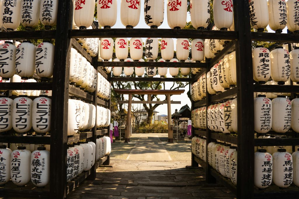 White paper lanterns at a shrine in Fukuoka, Japan, under a clear sky.